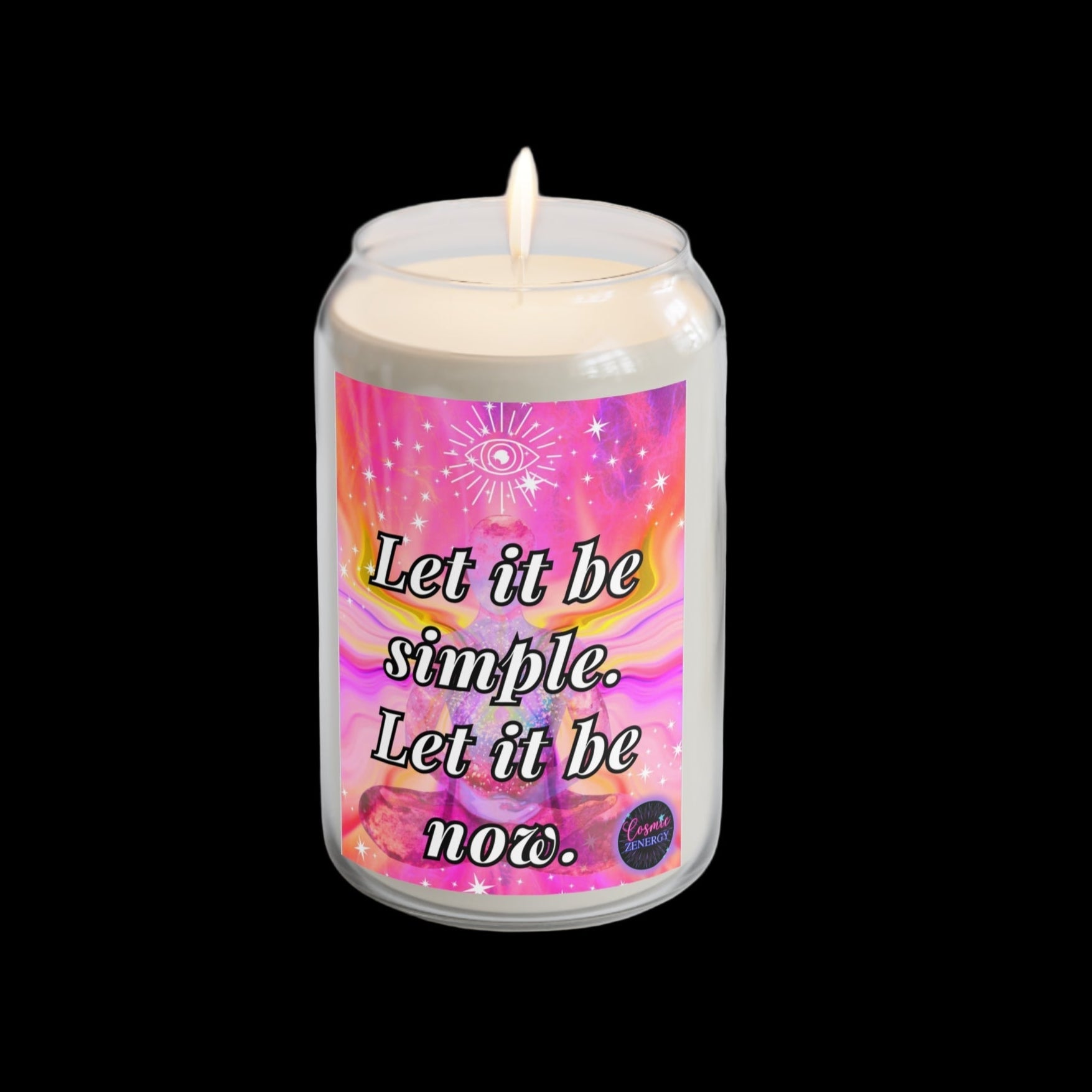 Candle with a colorful label on a white surface with a plant and watch in the background
